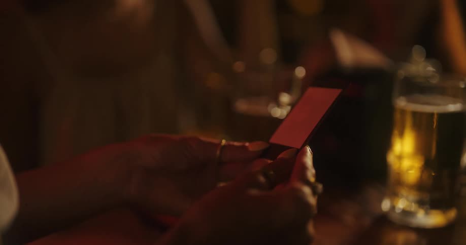 Hand shaking a photograph on a table with draft beer