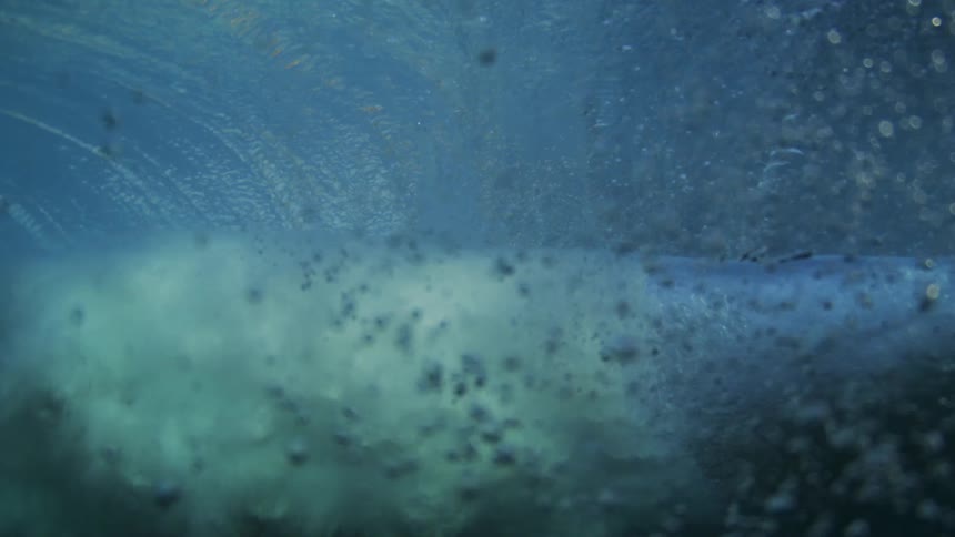 Underwater view of a breaking wave with bubbles and suspended sediments