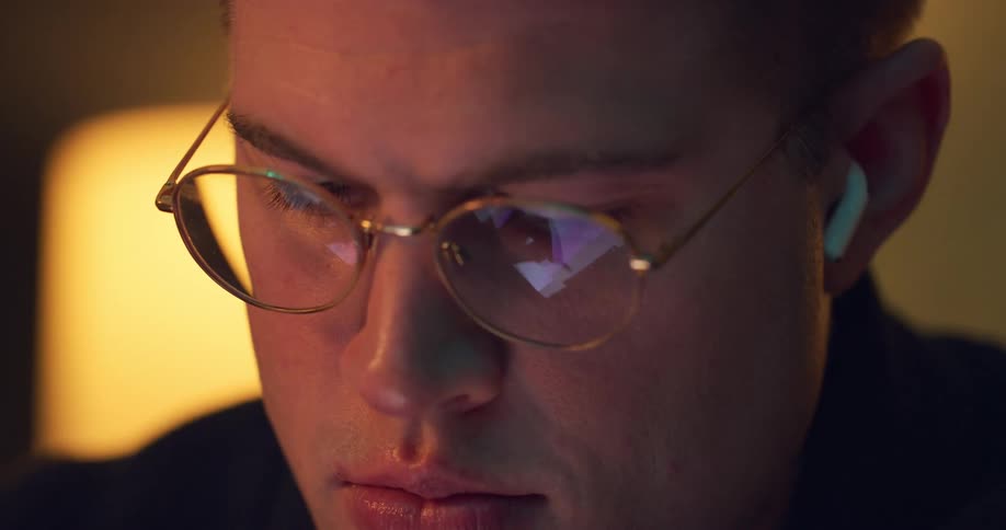 A young man looks at a computer screen while concentrating on his work