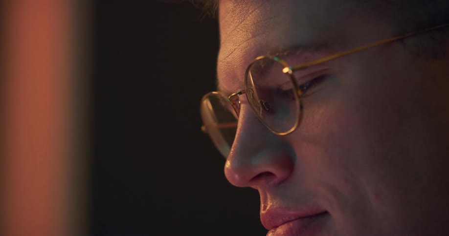 Closeup of a man with golden glasses looking intently