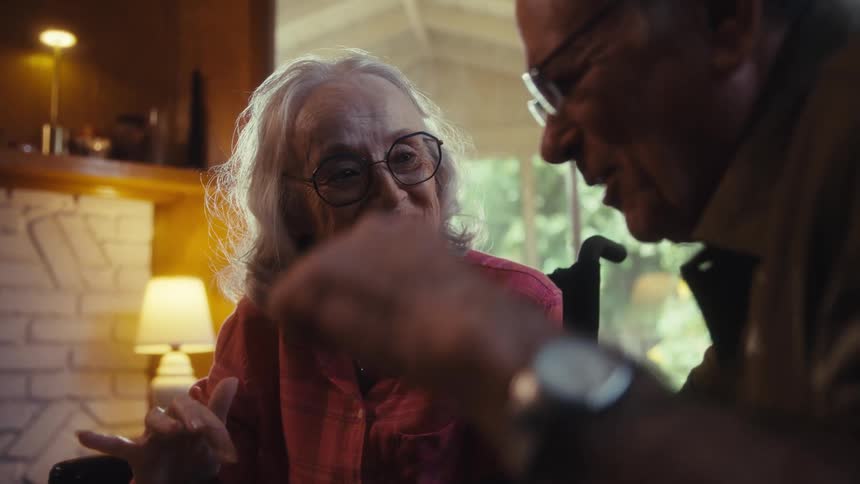 Elderly couple working together on assembling a puzzle on the table