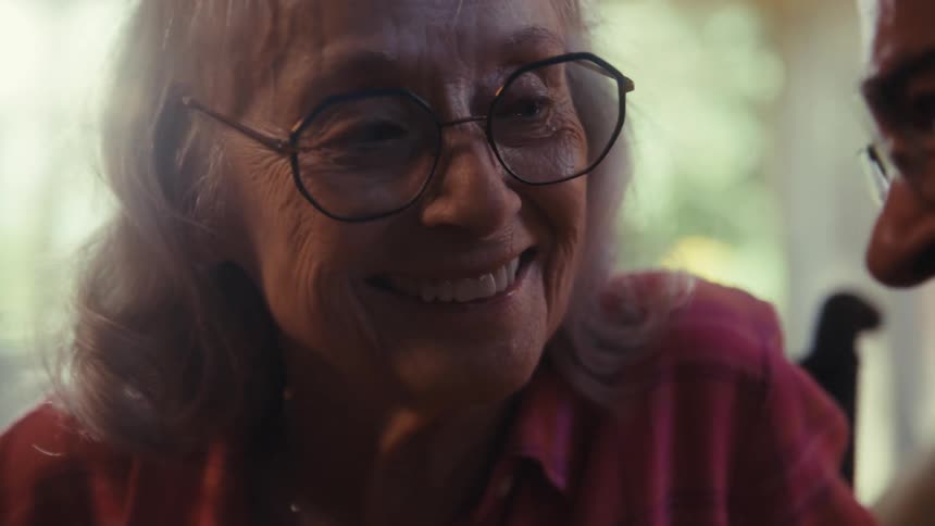 Elderly couple smiles closely in a moment of shared joy