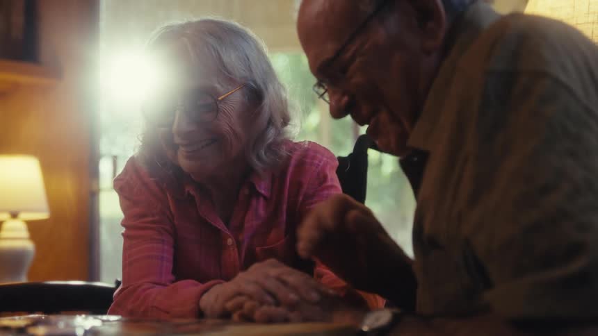 Two elderly people having fun playing puzzles