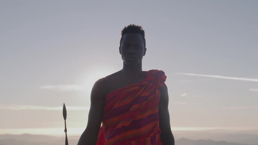 The man is holding a spear on a sunny day