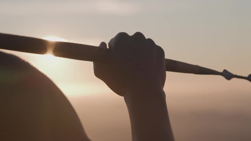 The man holds the spear up