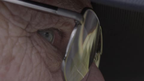 An elderly man is wearing eyeglasses