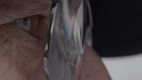 Moving vehicles reflect off of an elderly person's glasses