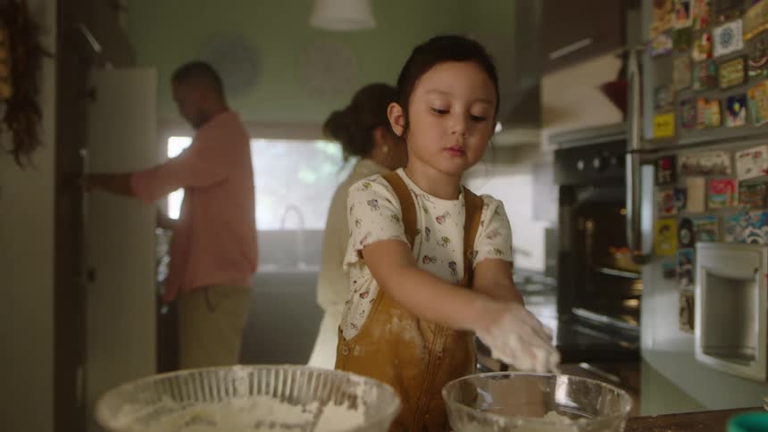 The family cooks together in the kitchen