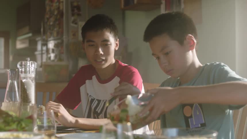 A family sits around the dining table sharing a meal together
