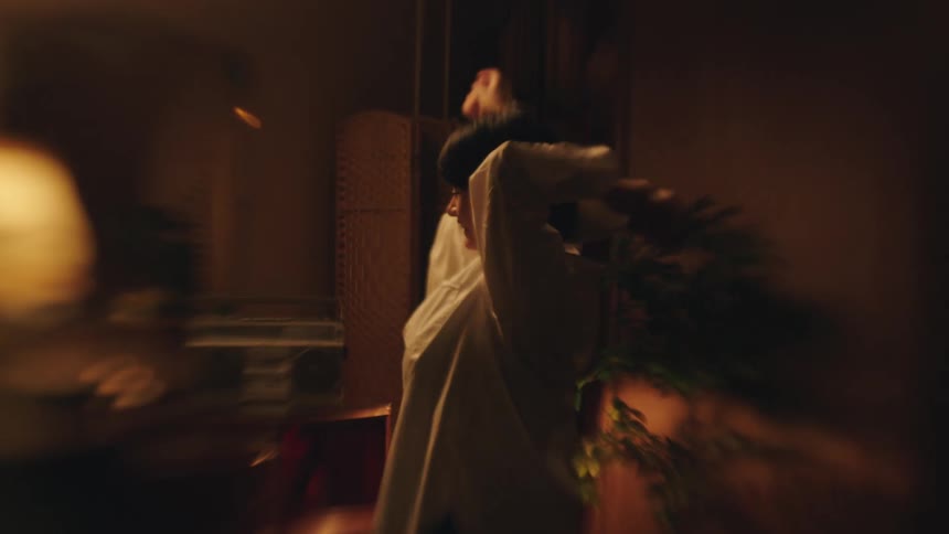 A couple indoors dancing and holding hands at night