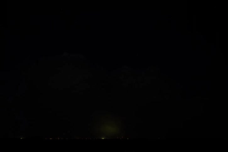 Lightning streaks through the clouds during a storm at night