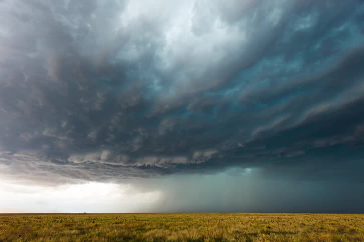 Storm clouds gathering and circling above a wheat field