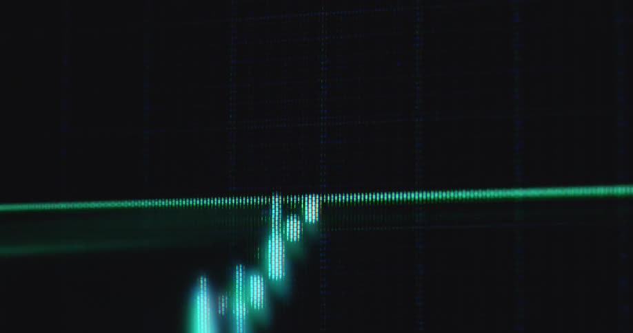 Green trend line drawing candles with wicks on dark pc screen creating bullish candlestick graph or pattern with upward tendency and positive price development symbolizing successful trade with profits via online trading platform or broker application