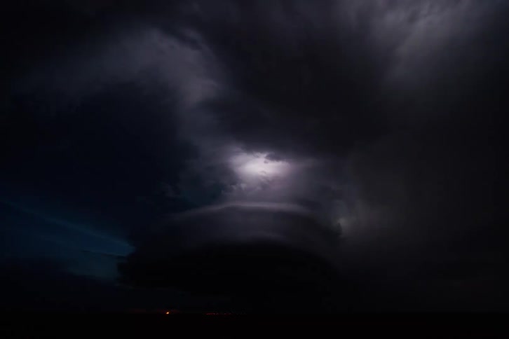 Lightning flashing repeatedly inside dark storm clouds at night