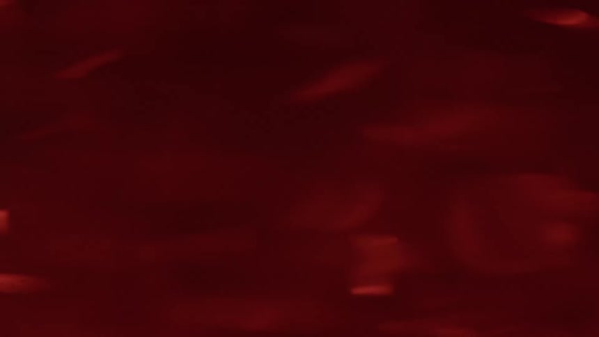 Red liquid swirling with diffuse reflections