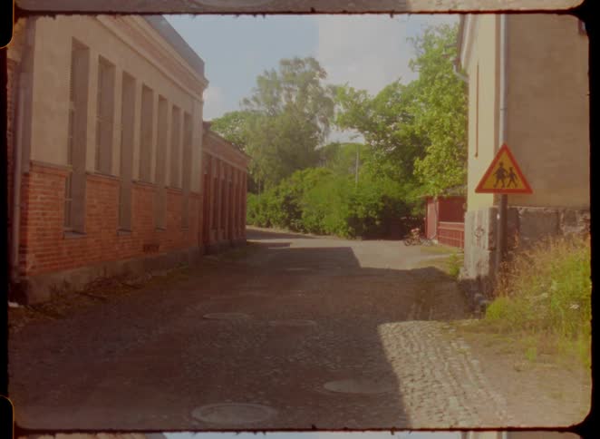 Road next to a sign between two buildings outdoors during day time