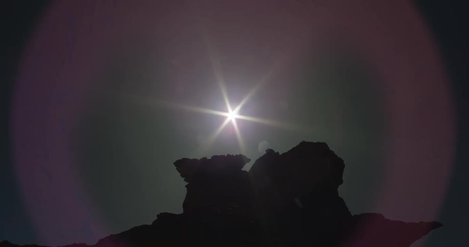 The sun shines above the rocks