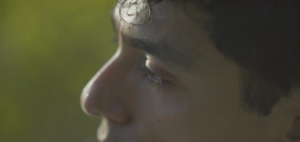 Male face in closeup highlights profile with a golden earring