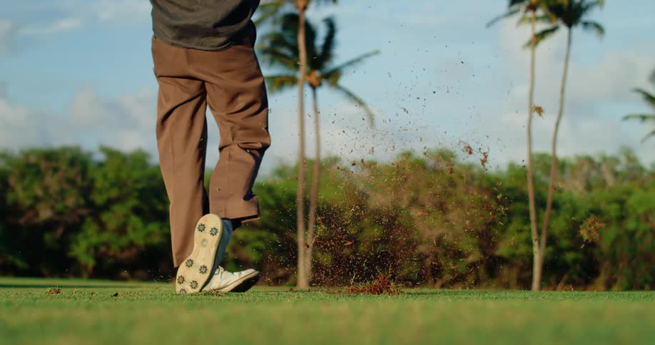 A golfer strikes the ball
