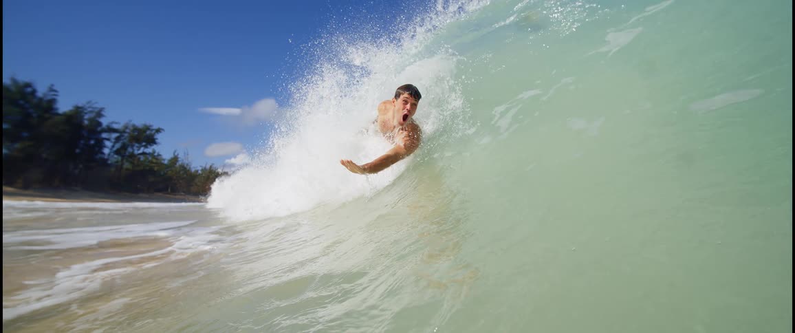 The man glides across the crashing wave