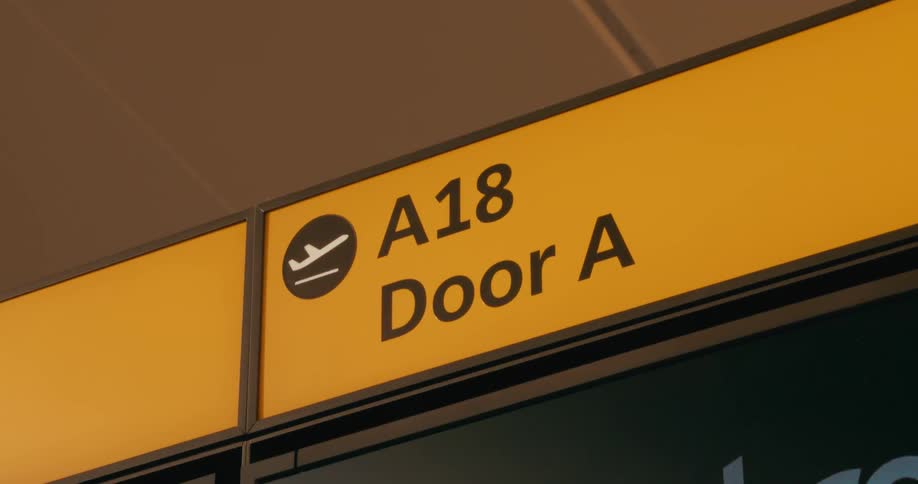 Yellow sign showing boarding gate a18 door a at an airport