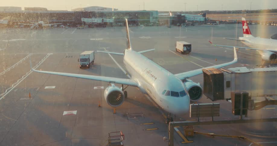 An airplane is parked at the airport gate being prepared for boarding