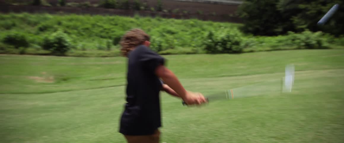 The video shows a young boy playing golf he lines up his shot takes a swing and misses the golf ball completely