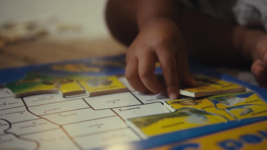 Two people being a child putting together a puzzle