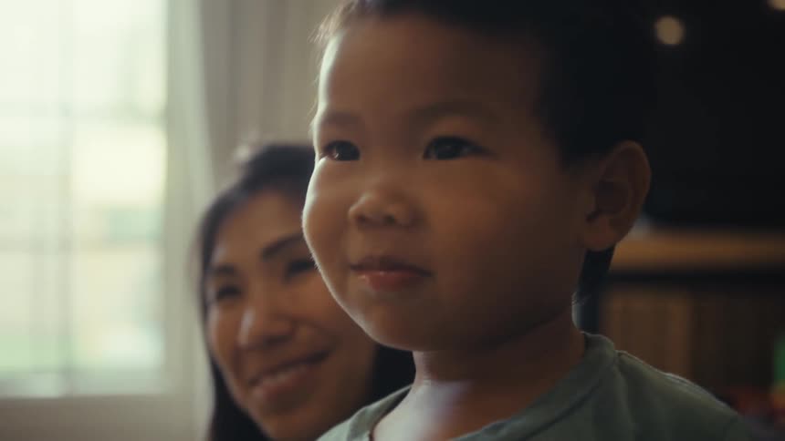 Little boy next to his mother in the living room
