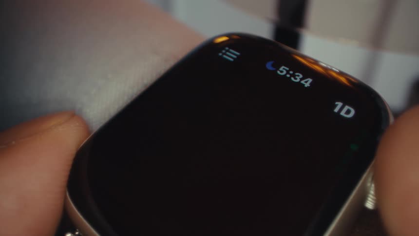 Man checking price graphs on a smartwatch indoors