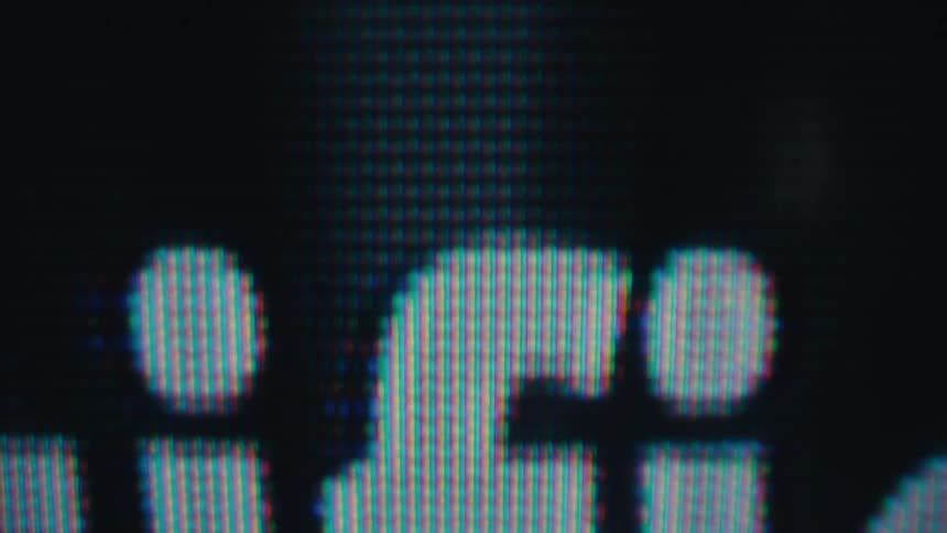 The word artificial appears in pixelated colorful text slowly fading in and out against a black background with a subtle static effect