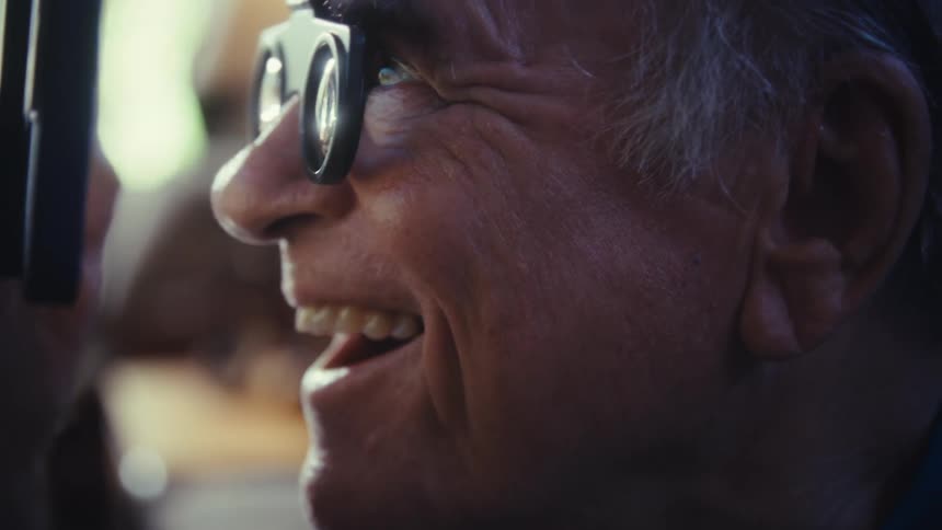 Cheerful elderly man using magnifying glasses