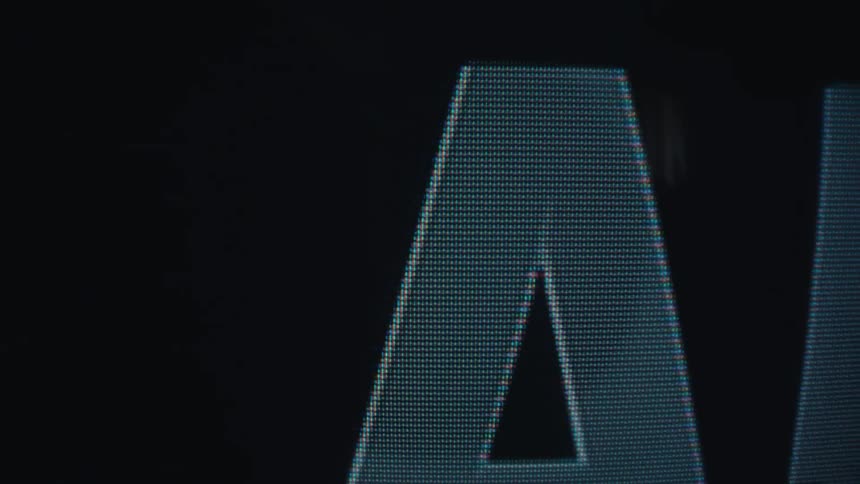 Enlarged letters a and i appear highlighted on a dark screen