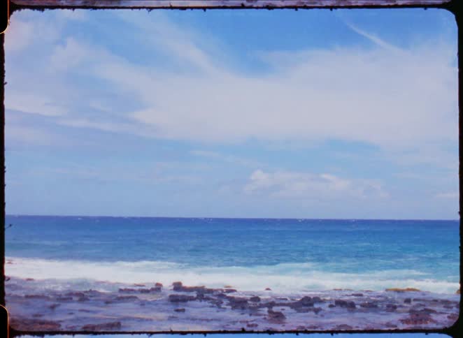 The ocean and waves on a rocky shore with water moving back and forth on the rocks as the waves come and go