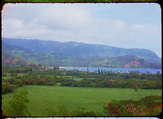 Landscape of greenish mountains surrounded by the sea