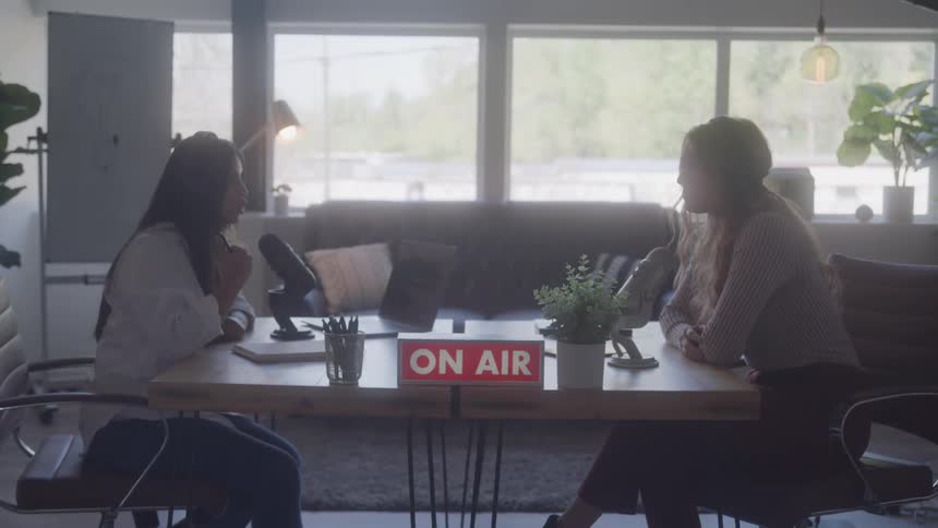 Two women having a discussion on a podcast while on air at midday