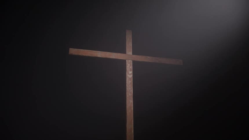 A spotlight shines on a wooden cross