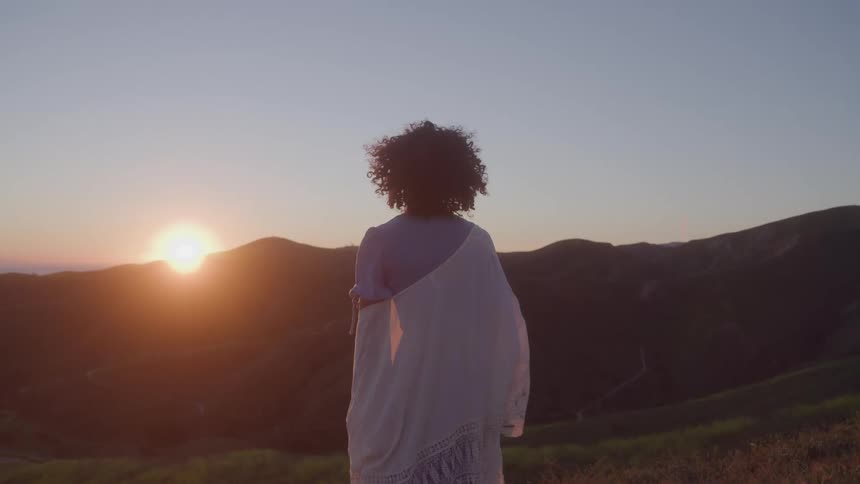 The woman is watching the sunrise