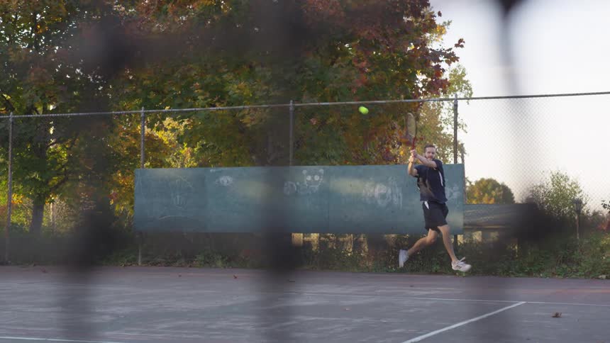 The man hits the tennis ball on the court