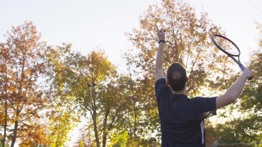 Man throwing a ball with a tennis racket
