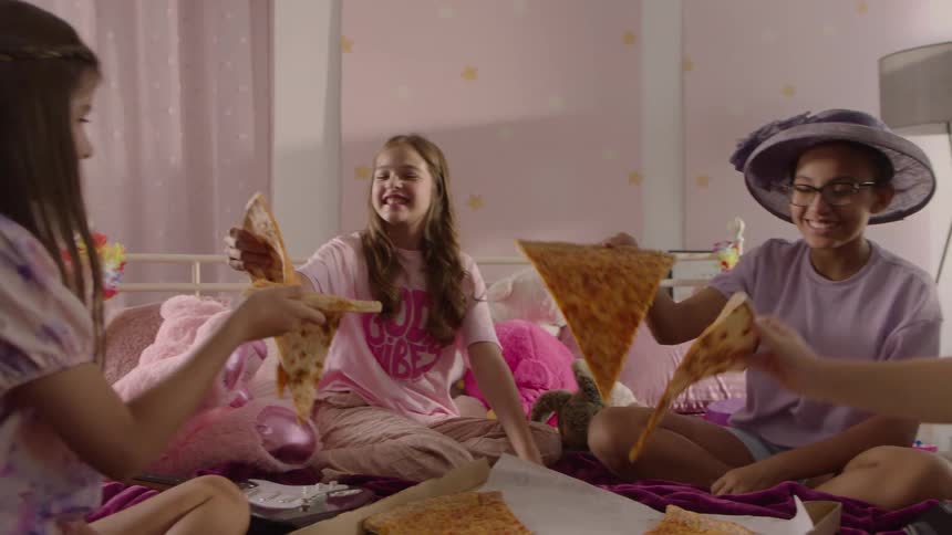 Friends all grab a slice of pizza and start eating