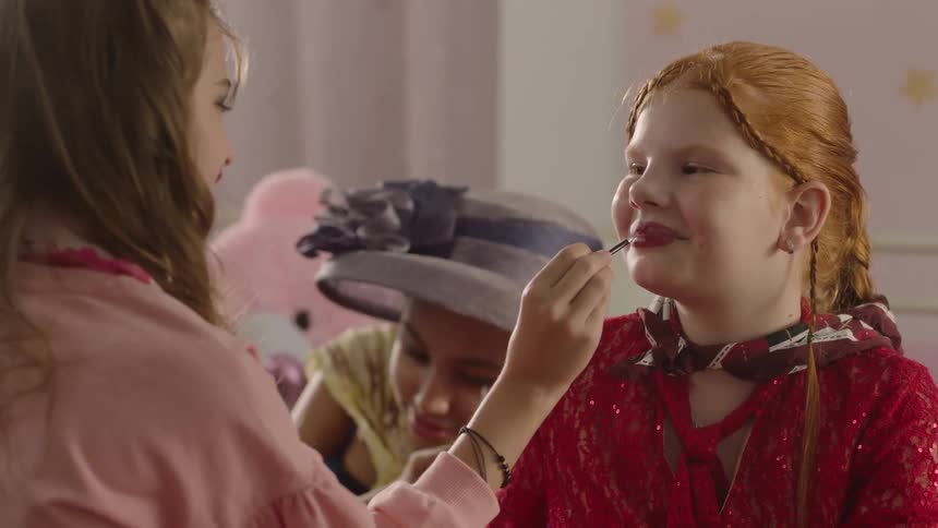 Girls enjoy playing dress up and doing makeup together