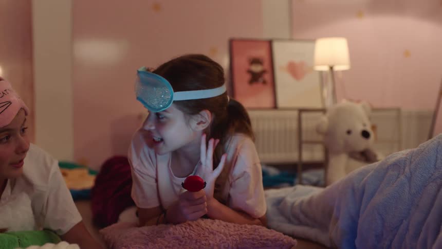 Girls lying on a bed during a sleepover talk