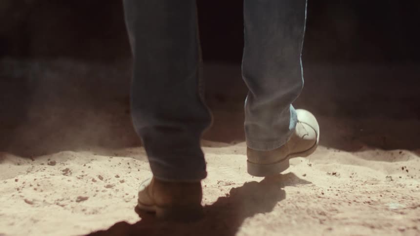 Person in shoes walking on the sand