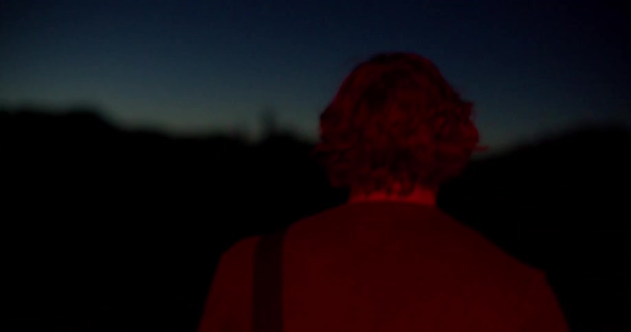 A person runs outdoors at night under the dark sky