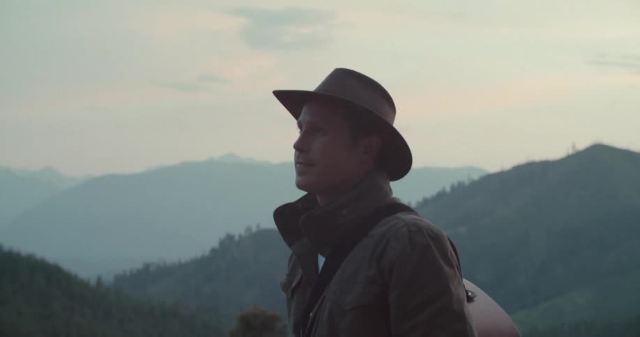 Man in hat walking through mountains