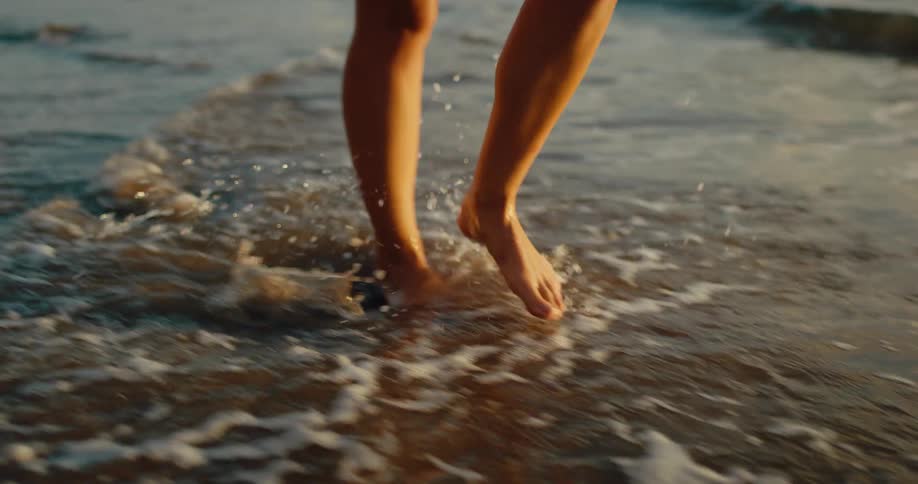 Close up of a womans legs as she walks across the sea shore during daytime