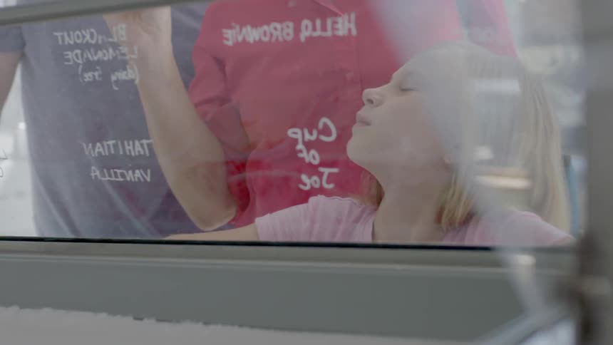 A family are picking out ice-cream in a shop