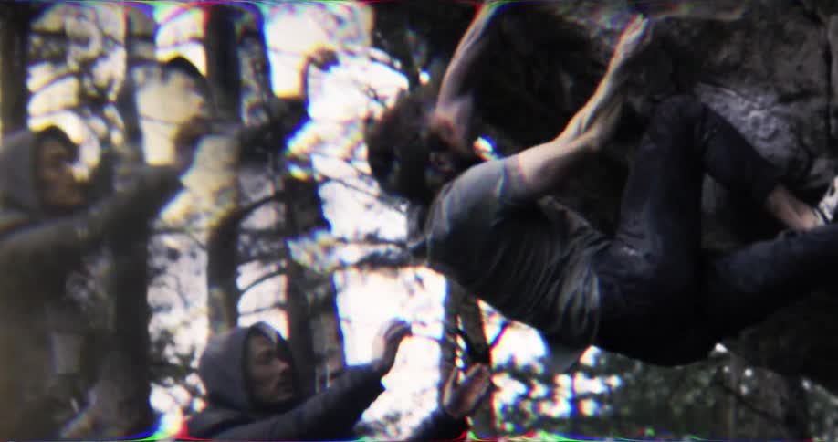 Man climbing a rock while another person supports him from below