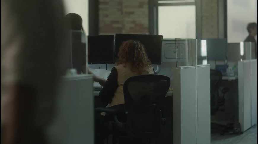A woman shows a folder to a coworker in the office
